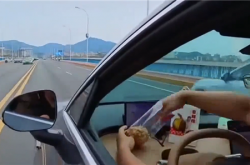 男子买新车炫智驾双手脱离方向盘吃东西被交警制裁